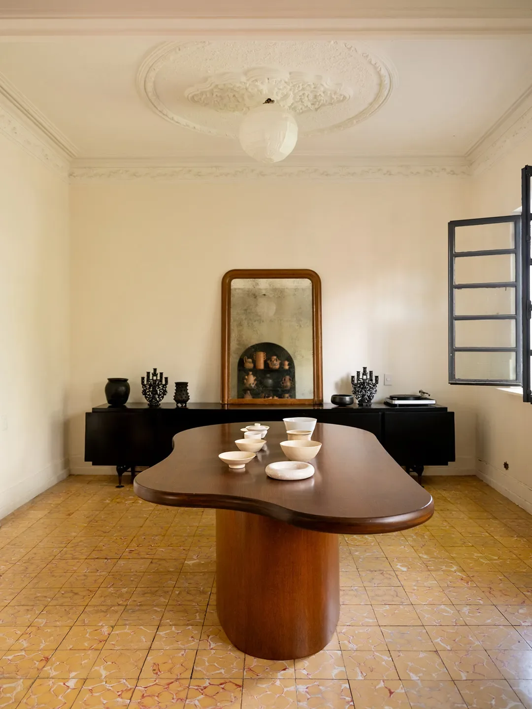 Casa de Reunión dining room with curved wooden table and ornate plasterwork
